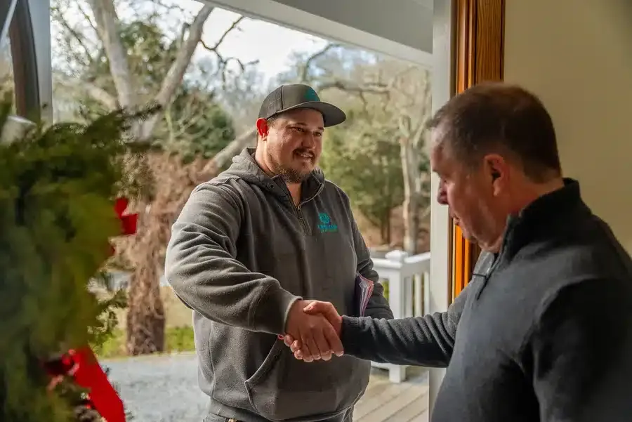 technician shaking customers hand in residential home on Cape Cod, MA.