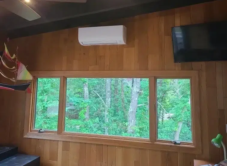 Indoor mini-split unit in a bright wood-paneled Cape Cod, MA family room